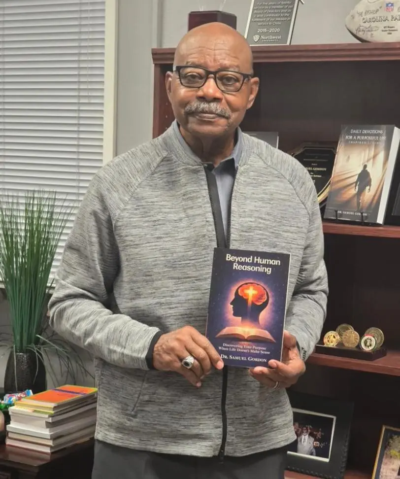 An author holding Beyond Human Reasoning in his office